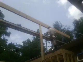 Carpenter setting a ridge beam over a new addition frame — Ice Dam Removal by Roofing Brothers in Jean