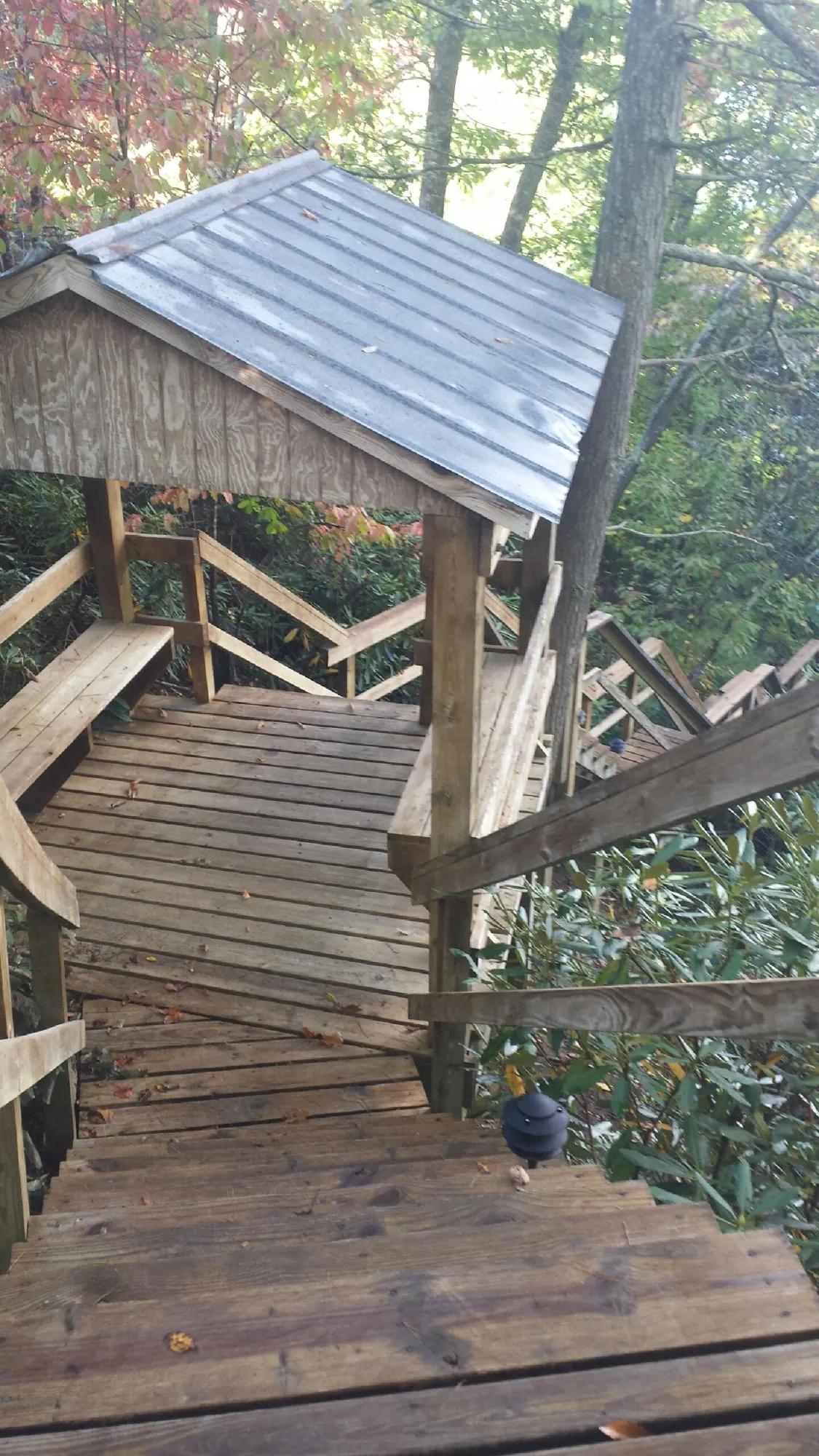 Metal roofed shelter over wooden steps on a wooded walkway — Skylight Repair & Installation work by our crew in Jean