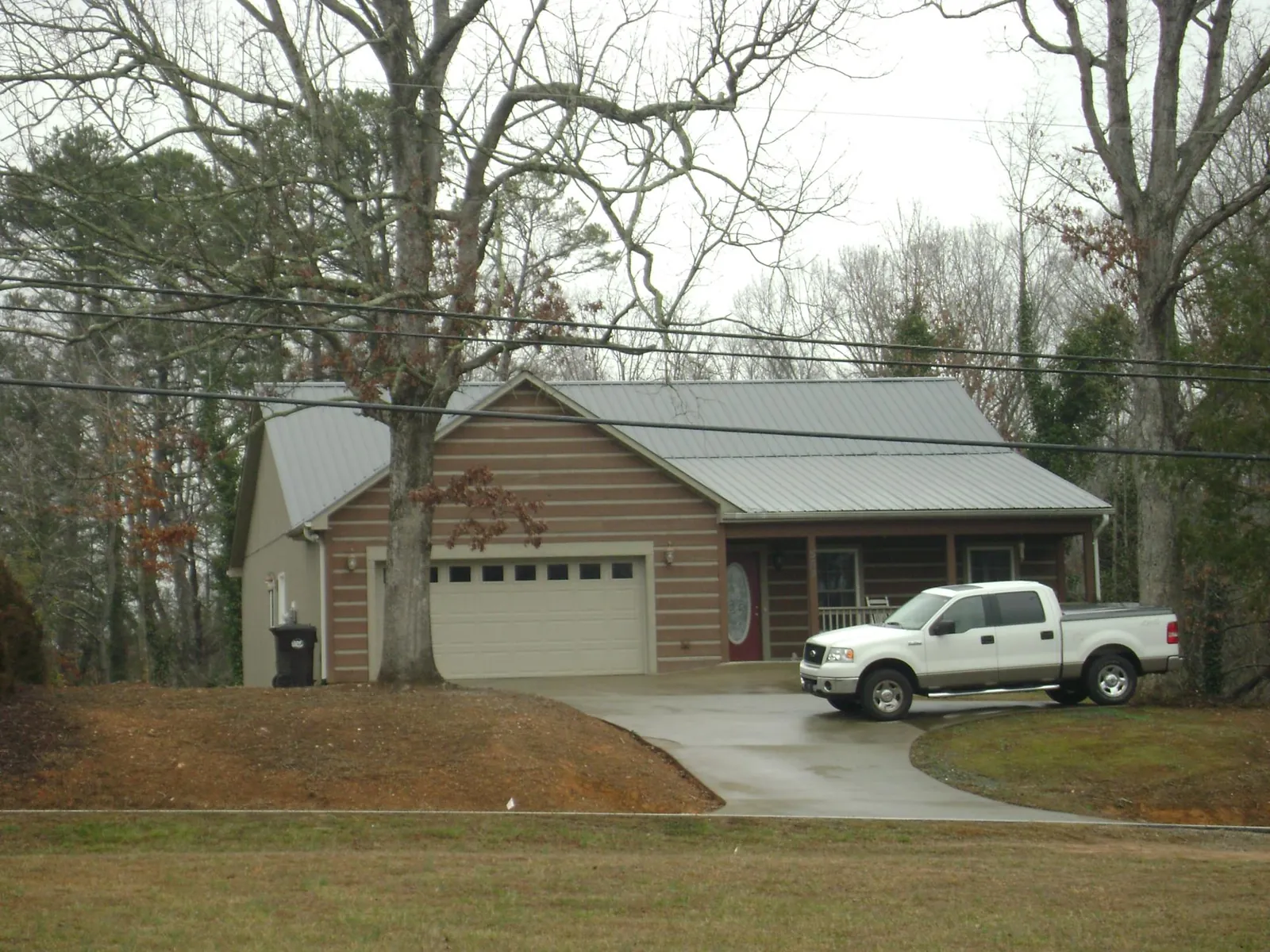 Gray metal roof on a log sided house with an attached two car garage in Jean